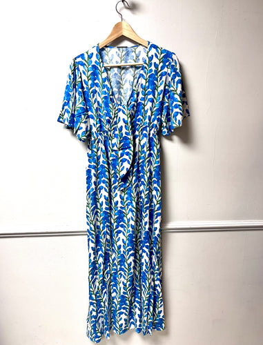Bright blue and green floral print dress on white. Tie at the bust with short sleeves