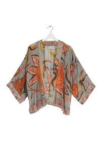 A short kimono of earthy tones contrasted against joyful burnt orange-coloured blooms all on a soft grey background
