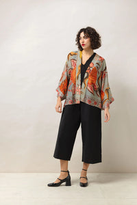 A short kimono of earthy tones contrasted against joyful burnt orange-coloured blooms all on a soft grey background