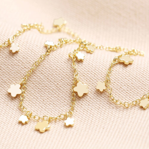 A simple chain necklace with a selection of dainty flowers of different sizes along its length