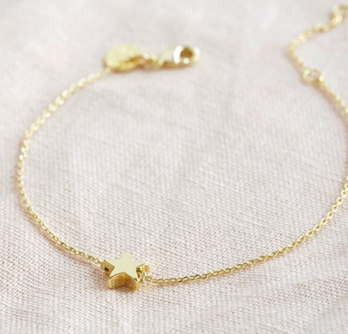 A golds tar charm on a fine chain bracelet with an extender chain.