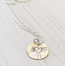 Load image into Gallery viewer, A sterling silver disc necklace with a pretty heart and radiating  dots emerging from it on a sterling silver chain.