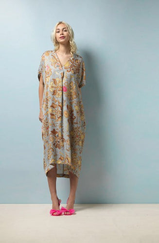 A midi length dress in a beautiful soft and elegant print based on Tudor silk embroidery. The background of the dress is pale grey blue with neutral tones to the print with subtle hints of pink and blue. A midi length, dropped shoulder short sleeve, V neck and pleat to front neck. One size. 