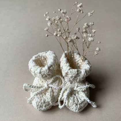 These handmade baby booties by Gooseberry Fool are made from a soft 100% organic cotton in India. In a timeless design and with matching cotton tie, they are the ideal new baby gift. Available in size 0-3 months and in 3 colourways. They are the perfect new baby gift. 