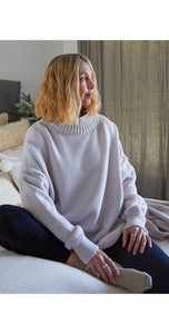 A luxurious 50% merino wool jumper with a funnel neck, loose fit and stunning side slits in a soft light oatmeal. 