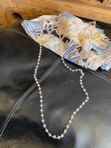 Soft pink iridescent beads attached to gold metal make this a beautiful long necklace with a clasp fastening. 