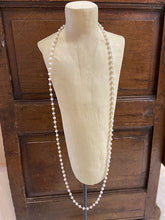 Load image into Gallery viewer, A long ladies necklace made from soft white iridescent beads attached to gold metal loops. Fastens with a clasp. Nickel free.