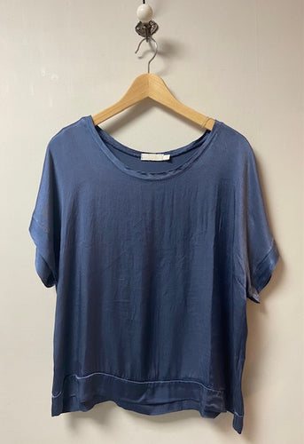 A silky fabric boxy style top. With short sleeves and a scoop neck, the fabric has a shimmer to it. With a double layer to the cuffs, neckline and hem, it is a luxe ladies top. 