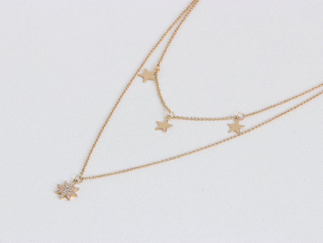 Double layered necklace with a larger encrusted star and three small stars on the shorter chain.