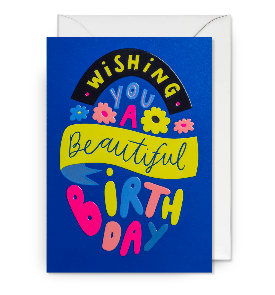 A royal blue card with the words Wishing You a Beautiful Birthday in bright lettering