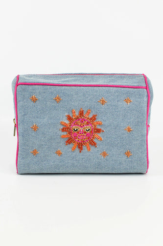 A MAKE UP BAG IN WASHED DENIM WITH A SPARKLY SUN FACE IN ORANGE, PINK AND GOLD EMBROIDERED BY HAND
