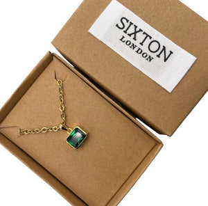 A faux emerald gem  on a link chain  Presented in a  box.