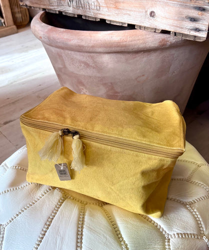 A canvas wash bag in a generous size in a murky yellow.