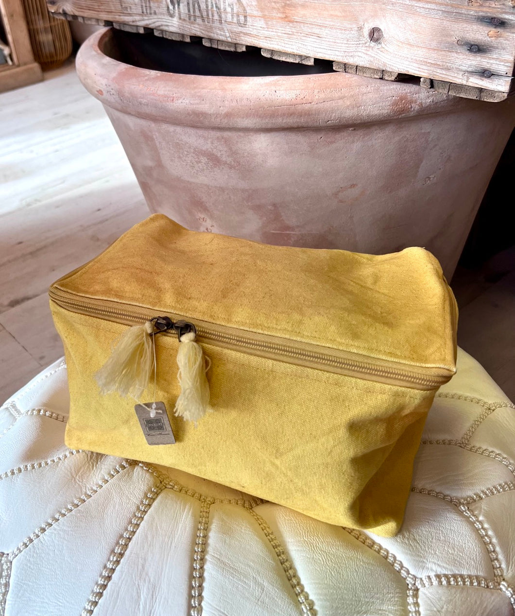 A canvas wash bag in a generous size in a murky yellow.