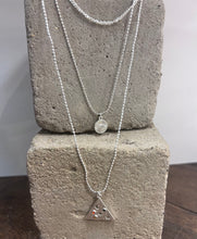 Load image into Gallery viewer, triple layered silver plated necklace with a triangular pendant with moon and stars and a circular one with the evil eye within sun rays