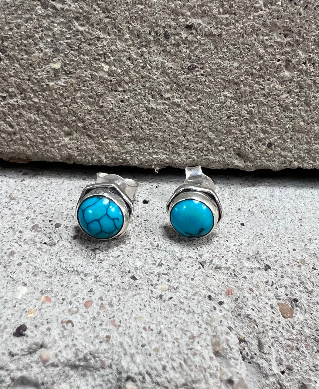 Small sterling silver studs with a round turquoise stone and a hexagonal surround