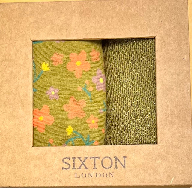A box of two pairs of socks. floral green and plain green with sparkles
