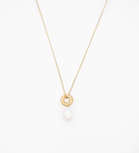 A natural pearl falling from a gold ring on a gold adjustable chain necklace