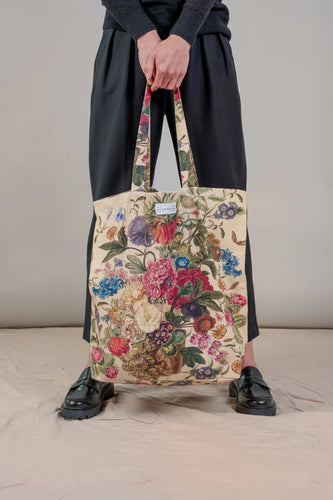 A beige tote bag with a wonderful array of flowers printed on it