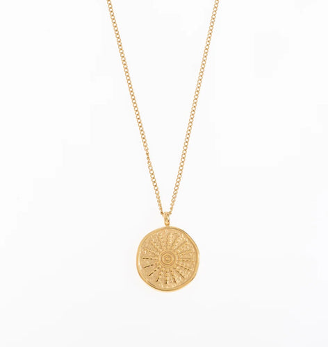 A dainty chain with a sun etched on a round pendant