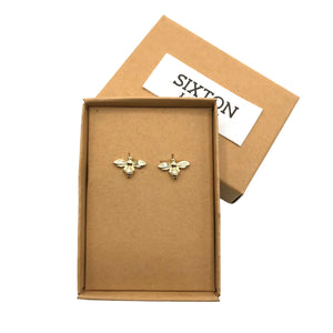 Tiny gold bee earrings in a gift box