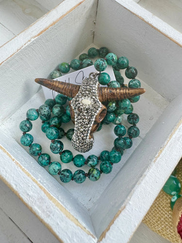 Green jade beaded necklace with a glitzy crystal buffalo head pendant