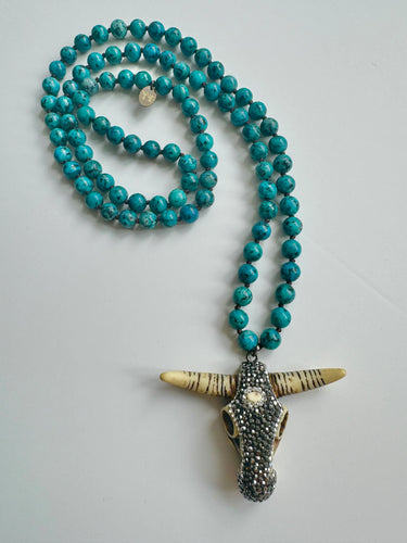 Buffalo head pendant with crystals on a long teal bead chain