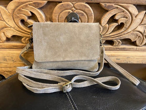 A handbag made from suede in a soft taupe colour. Wear as a clutch bag or crossbody bag, with the two straps included. Flap closure and zip to main compartment. Inner zipped pocket. 