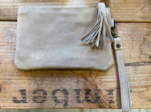 Load image into Gallery viewer, A clutch bag made in Morocco in genuine suede in a neutral colour. With an oversized tassel to the zip puller and a detachable wrist strap. 