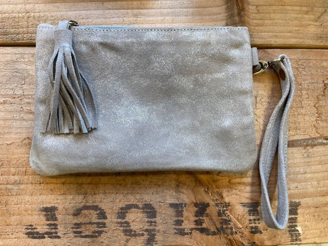 A handmade clutch bag from Morocco in metallic leather in a neutral shade. With an oversized tassel to the zip puller, it has a detachable wrist strap. 