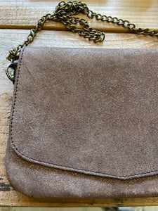 A rose gold metallic leather handbag, handmade in Morocco. With a detachable bronze chain strap, it has a flap closure and a zip fastening to the main compartment. 