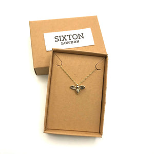 Gold bee necklace in a box