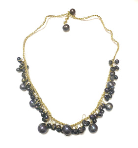 Delicate necklace of dark pearl on gold yarn 