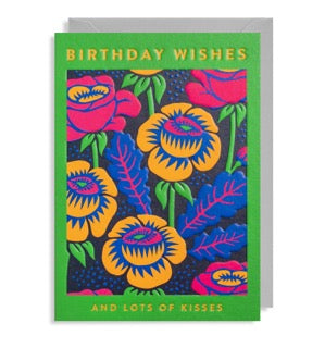 A vibrant card in the brightest green with a selection of pink and peach flowers on the front.