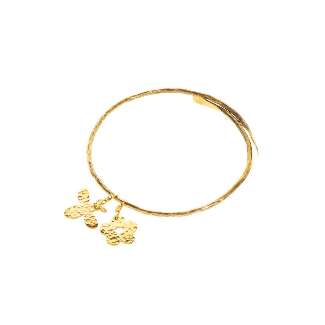A small bee and flower made from beaten brass and attached to a brass bangle