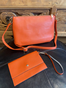 A 2 in 1 Crossbody and Clutch Bag. The crossbody bag features a zip to the top and a detachable and adjustable shoulder strap. Each bag has a contrast colour lining. Included inside the crossbody bag is a small clutch bag, that can be worn over your wrist, and with a magnetic closure to keep it secure. 