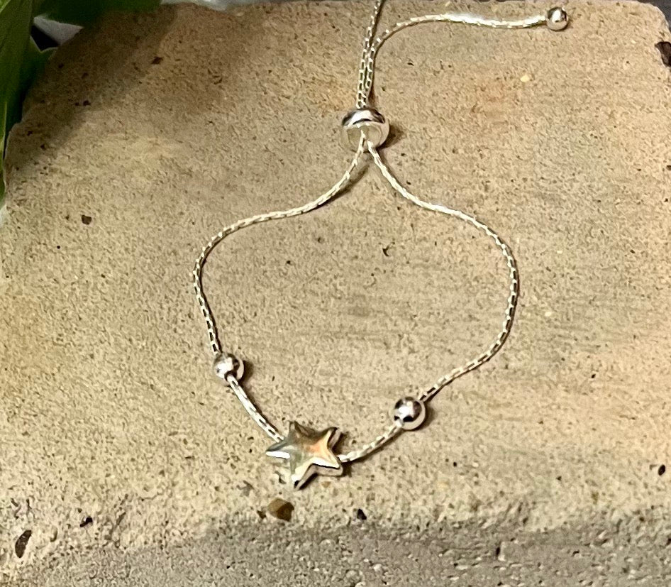 A sterling silver adjustable snake chain with a single star and two silver beads