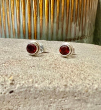 Load image into Gallery viewer, Ruby stud earrings in a simple sterling silver casing. These studs have sterling silver butterfly backs 