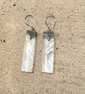 Small mother of pearl drop earrings with a delicately detailed casing at the top 