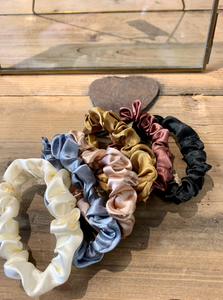 Small satin hair scrunchies in a variety of soft tones - black, brown, golden, taupe, grey and cream