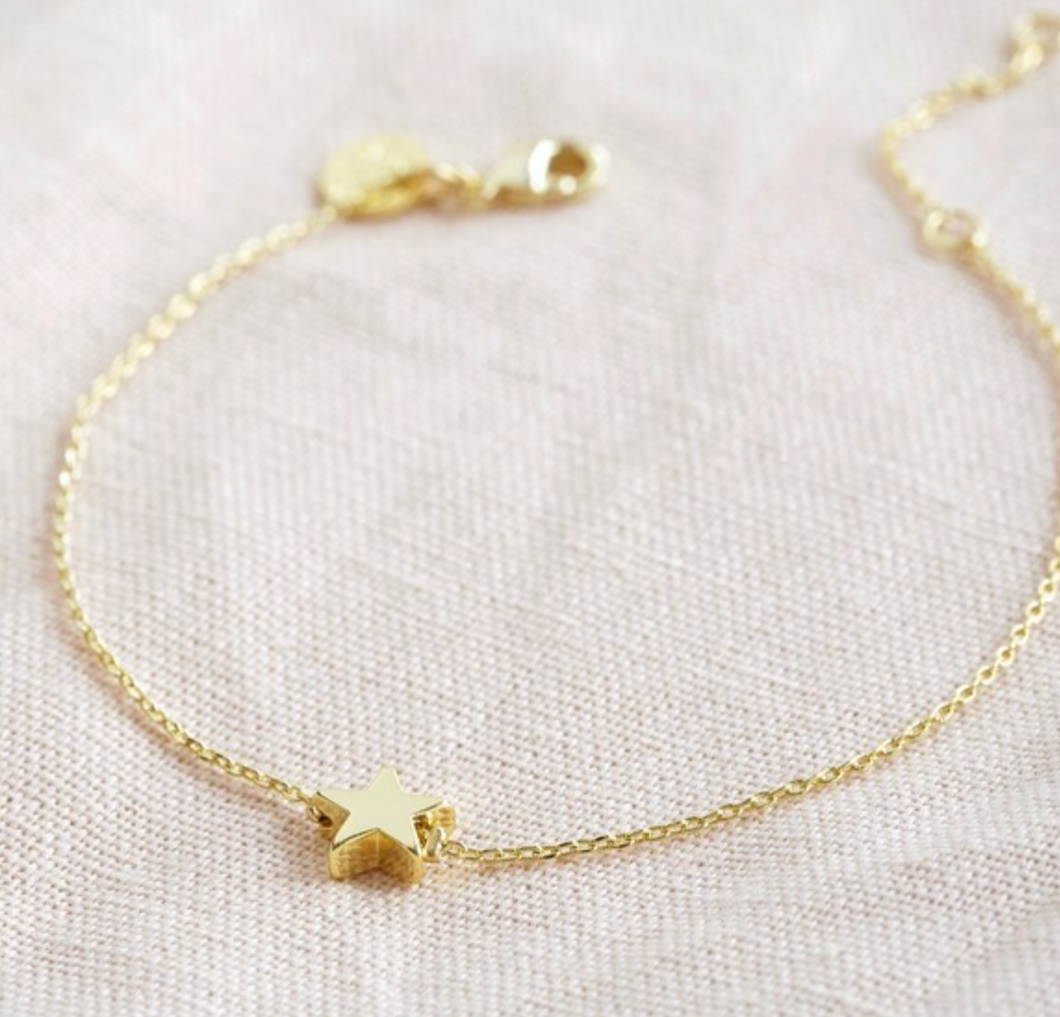 A golds tar charm on a fine chain bracelet with an extender chain.