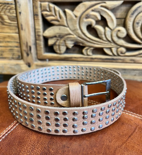 A tan leather belt with four rows of studs along the length of it.
