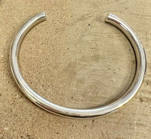 A simple shiny sterling silver adjustable cuff bracelet .