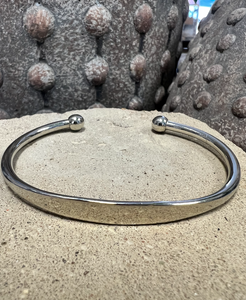 Narrow simple cuff bracelet in rhodium plated brass giving it a shiny silver appearance 