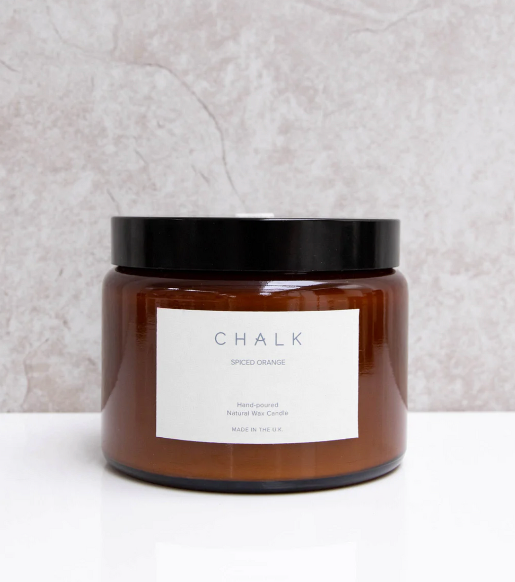 An amber jar candle pot with a triple scented candle of spiced orange