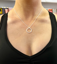 Load image into Gallery viewer, A hammered effect sterling silver circle pendant on a sterling silver chain.