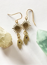 Load image into Gallery viewer, delicate handmade brass hand and star dangling earrings have a star on one hand and a heart on the other and a beautiful sunshine above. On gold plated hooks