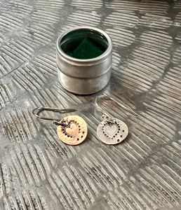 sterling silver disc earrings with a heart hand hammered onto them. On sterling silver hooks. Presented in a little metal pill box.