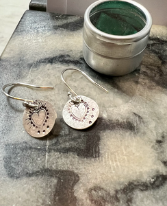 sterling silver disc earrings with a heart hand hammered onto them. On sterling silver hooks