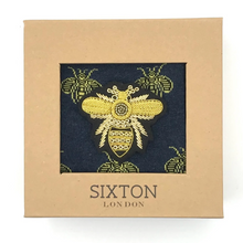 Load image into Gallery viewer, A pair of navy blue socks with yellow bee designs on them and a large bee pin. All presented in a box.